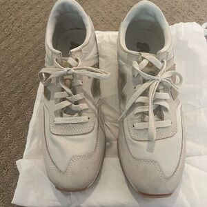 Woman’s New Balance white/ beige gold tennis shoes size 9.5
